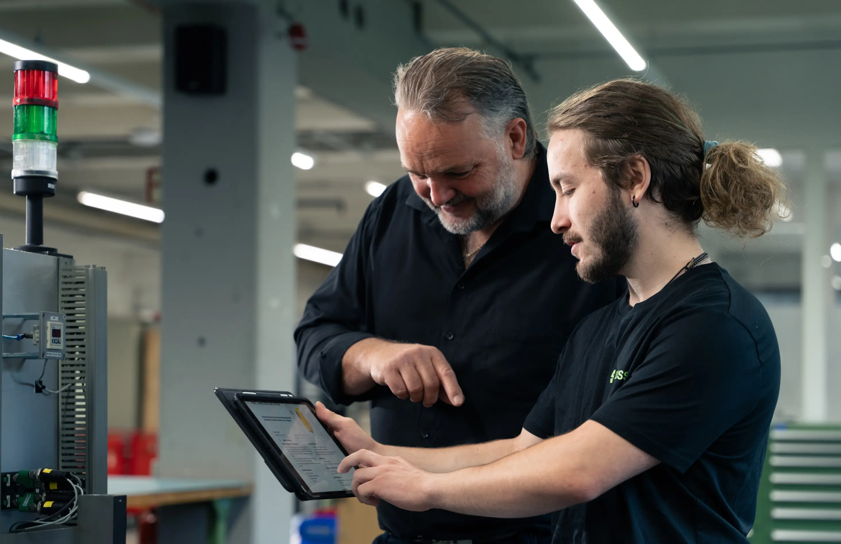 Two Men Controlling Data on Tablet.webp