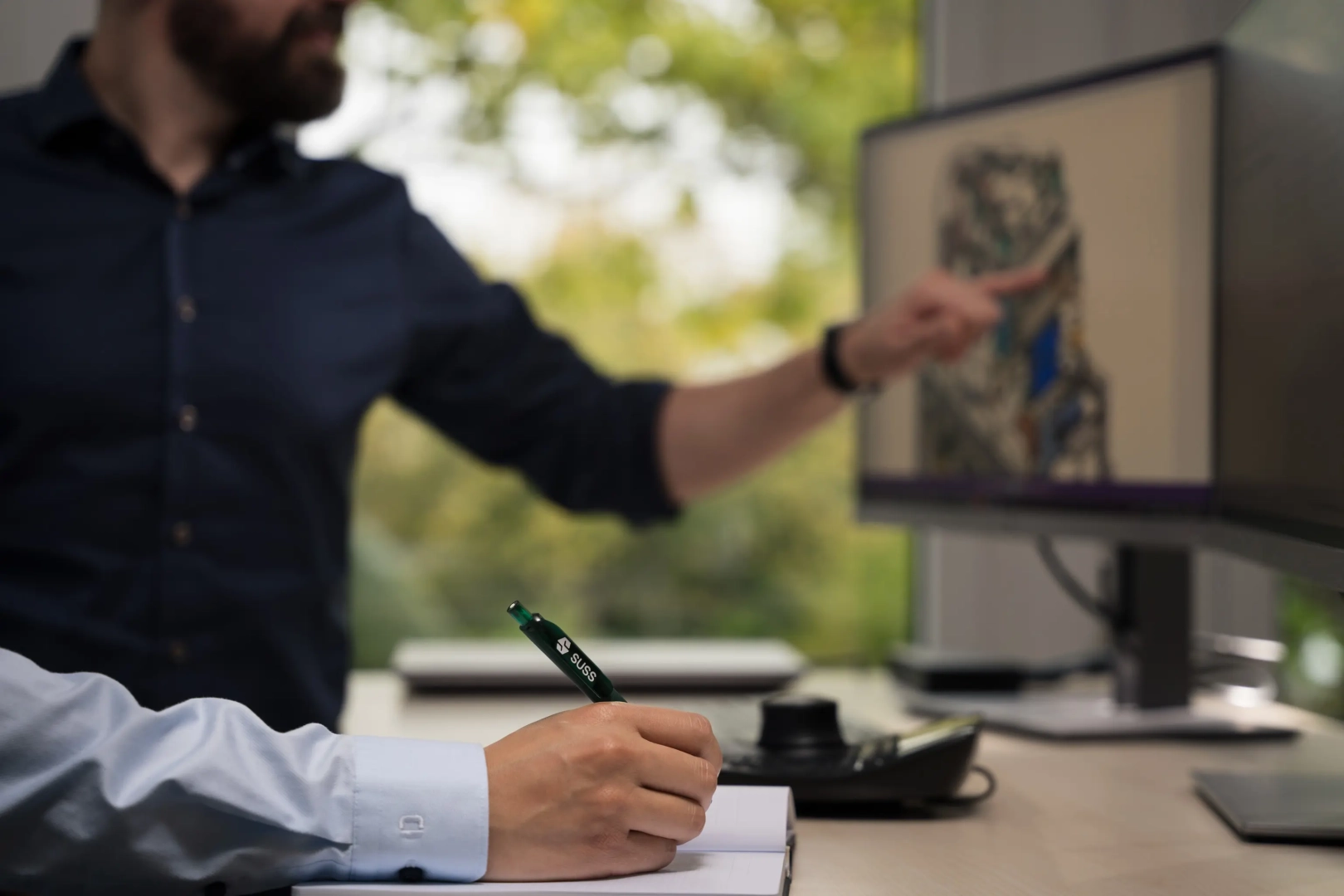 Man Taking Notes in Front of PC
