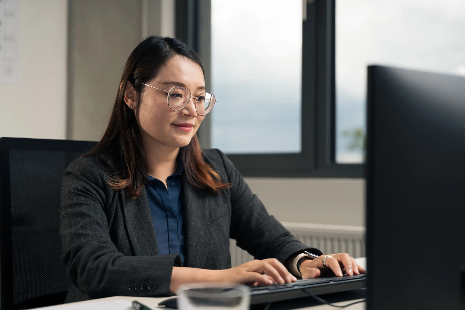 Woman Sitting at Desk and Typing